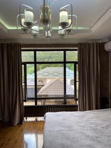 a bedroom with a bed and a large window at Villa Qusar in Qusar