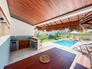 una cocina al aire libre y una piscina con techo de madera en Casa Janela da Lua, en Icaraí