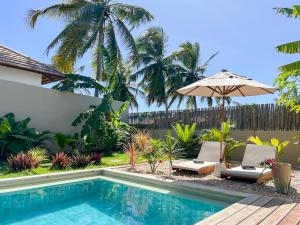 una piscina con 2 sillas y una sombrilla en Casa Janela da Lua, en Icaraí