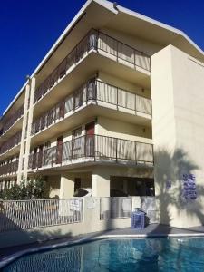 un edificio de apartamentos con piscina frente a él en Qubed San Antonio en San Antonio