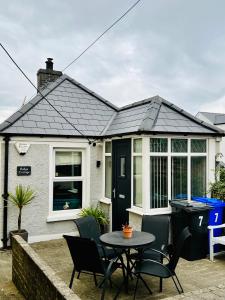 a house with a table and chairs in front of it at Ridge Cottage Portrush in Portrush