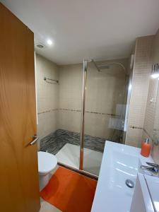 a bathroom with a shower and a toilet and a sink at Superbe appartement rénové, résidence avec piscine in Roses