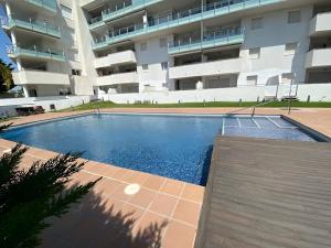 a swimming pool in front of a building at Superbe appartement rénové, résidence avec piscine in Roses