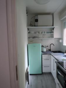 uma pequena cozinha com um frigorífico azul em Runa em Zagreb