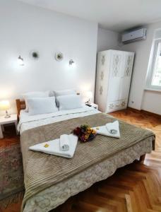 a bedroom with a bed with two napkins and flowers on it at Palace Luxury Apartments The Heart of Belgrade in Belgrade