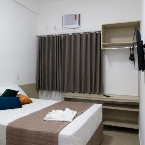 pokój hotelowy z łóżkiem i oknem w obiekcie FRATELLI PREMIUM HOTEL w mieście Elói Mendes