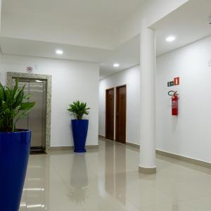 a hallway with two potted plants in a building at FRATELLI PREMIUM HOTEL in Elói Mendes