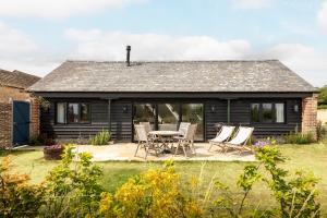 a cottage with a table and chairs in the yard at Linseed Barn- Stamford Holiday Cottages in Stamford