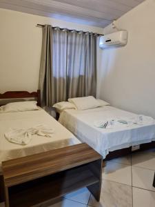 2 camas en una habitación con ventana en Maika'i Pousada en Balneário Camboriú