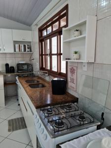 a kitchen with a stove and a counter top at Maika'i Pousada in Balneário Camboriú