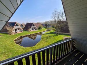 a view from the balcony of a house with a pond at Vakantiehuisje in Gramsbergen in Gramsbergen