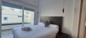 a bedroom with a bed and a large window at La perla blanca in M'diq