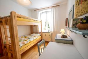 a small room with a bunk bed and a table at Landhauswohnung mit wildromantischem Garten in Füssen