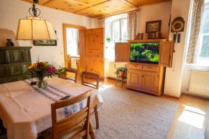 una sala da pranzo con tavolo e TV di Landhauswohnung mit wildromantischem Garten a Füssen