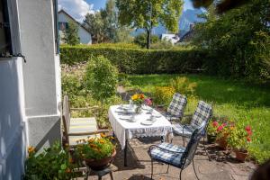 un tavolo e sedie in un giardino fiorito di Landhauswohnung mit wildromantischem Garten a Füssen