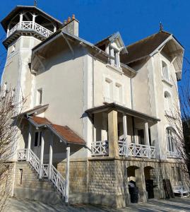 een groot wit gebouw met een toren bovenop bij Le Manoir des Lys in Tilly-sur-Seulles
