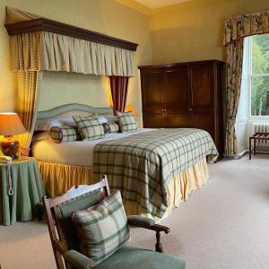 um quarto com uma cama e uma cadeira em Bunchrew House Hotel em Inverness