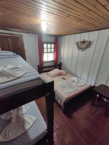 una piccola stanza con due letti e una finestra di Pousada Trilha do Farol a Ilha do Mel Altre 34 foto