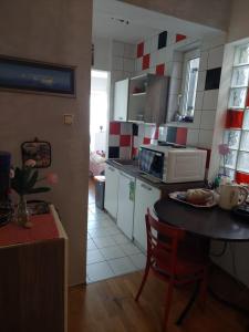a small kitchen with a table and a microwave at Vita apartments in Zagreb
