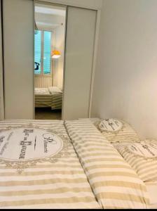 - 2 lits dans une chambre avec un miroir dans l'établissement Au cœur de Cannes, à l’angle de la rue d’Antibes, à Cannes