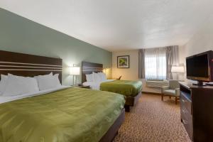 a hotel room with two beds and a flat screen tv at Quality Inn Alexis Rd in Toledo
