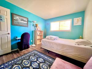 1 dormitorio con paredes azules, 1 cama y 1 silla en WHOLE Family - Rosemont en Sacramento
