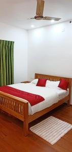 Schlafzimmer mit einem Holzbett und einem Deckenventilator in der Unterkunft Moon Homestay in Santhanpara
