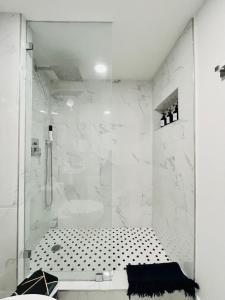 een witte badkamer met een douche en een bad bij Our Lovely Nest, Free Parking & Wi-Fi in Miami