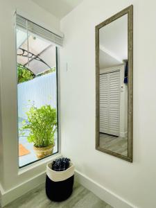 a mirror on a wall next to a window at Our Lovely Nest, Free Parking & Wi-Fi in Miami