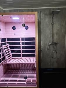 a pink bathroom with a shower and a bench at Modern & Cozy Apartments Close To Nature, West Lofoten in Sørvågen