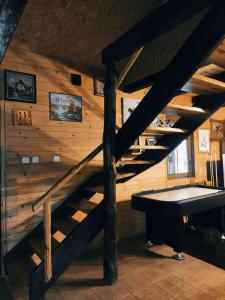 a staircase in a room with a ping pong table at Leśna Osada Szegdy 