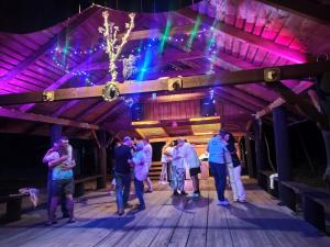 un grupo de personas bailando en el escenario en una fiesta en Leśna Osada Szegdy 