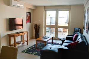ein Wohnzimmer mit einem Sofa und einem TV in der Unterkunft Brougham Arms Hotel in Bendigo
