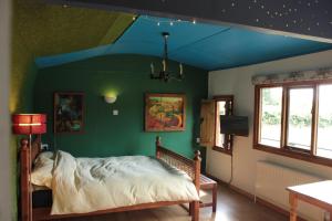 ein Schlafzimmer mit einem Bett mit blauer Decke in der Unterkunft Couples Camping Cabin in Ashbourne