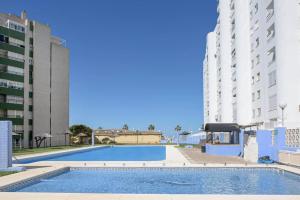 una piscina en medio de dos edificios altos en Valdelagrana: primera línea de playa., en El Puerto de Santa María