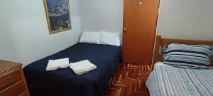 małą sypialnię z łóżkiem z ręcznikami w obiekcie Apartamento Marco Airport w mieście Lima