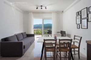 a living room with a couch and a table and chairs at Marina in Rabac