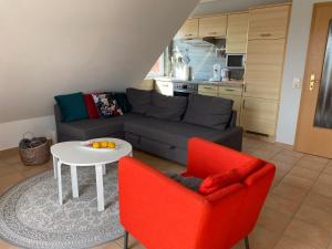 a living room with a couch and a table and two chairs at FeWo Herzstück - Neßmersiel in Neßmersiel