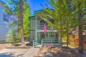 a green building with a flag in front of it at San Bernardino Mtn Retreat with Furnished Deck in Running Springs
