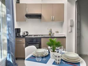 a kitchen with a table with plates and wine glasses at chatenay 1 in Paris