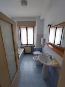 a bathroom with two sinks and a tub and two toilets at Casa Celeste in Farra dʼAlpago