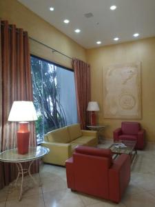 sala de estar con sofá, sillas y mesa en Suíte Palace, en Río de Janeiro