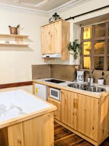 クエンカにあるLa Casa Cuencanaの木製のキャビネットとシンクを備えたキッチン