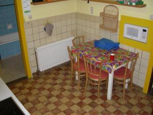 eine Küche mit einem Tisch mit Stühlen und einer Mikrowelle in der Unterkunft Ferienhaus Haus am Ufer in Gaienhofen