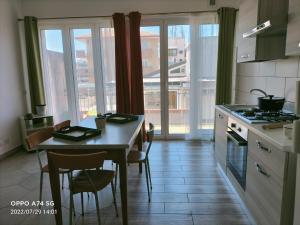 uma cozinha com mesa e cadeiras e uma cozinha com janelas em Apartment with terrace - dai fratelli Gurrieri em Ragusa