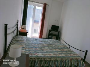 um quarto com uma cama e uma janela em Apartment with terrace - dai fratelli Gurrieri em Ragusa