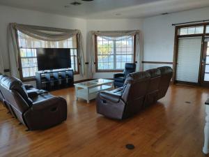 a living room with leather furniture and a flat screen tv at Villa Melbourne inter-coastal 2 floors 7br in Melbourne