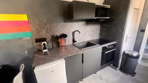 Kuchyňa alebo kuchynka v ubytovaní Capsule Art Déco - Jacuzzi - Netflix - Home Cinéma - Arcade de jeux & Nintendo switch - 2 chambres - Filet suspendu
