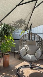 a wicker chair sitting under an umbrella on a patio at Condesa Cibel in Mexico City