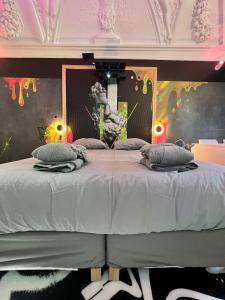 - une chambre avec un grand lit orné d'une peinture murale dans l'établissement Capsule Art Déco - Jacuzzi - Netflix - Home Cinéma - Arcade de jeux & Nintendo switch - 2 chambres - Filet suspendu, à Valenciennes